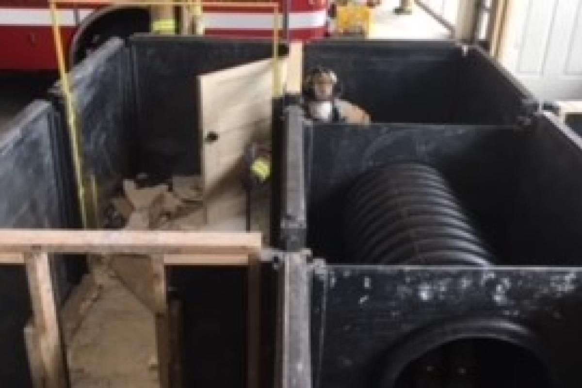 Firefighter sounding the floor with a tool to determine floor stability before entering the room