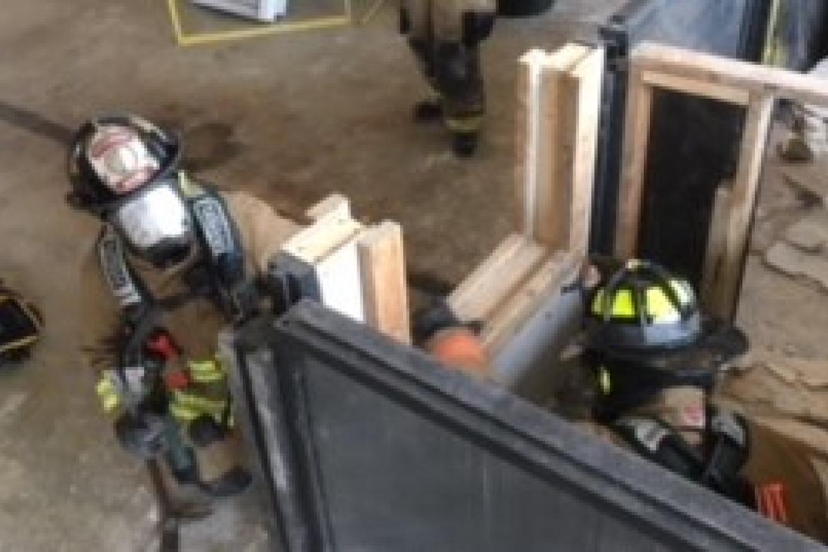 Firefighters continuing exiting building via the simulated window