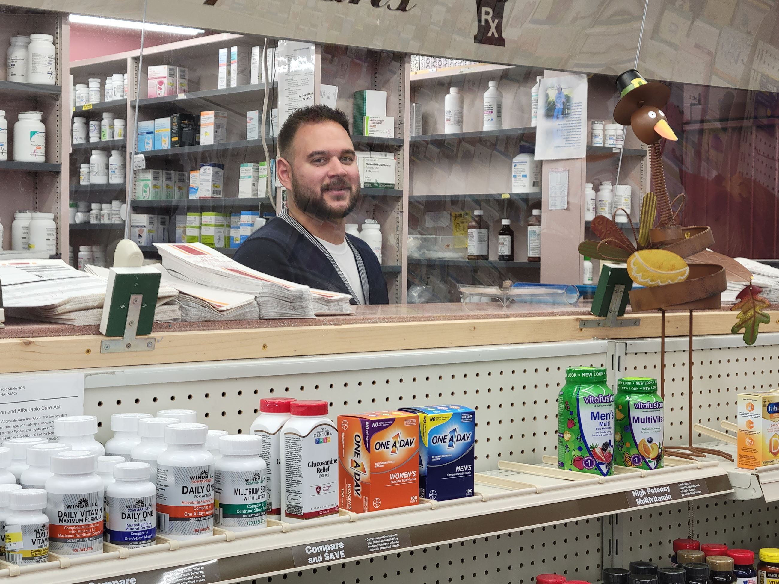 Jonathan Kontos behind the counter at Alexander's Pharmacy