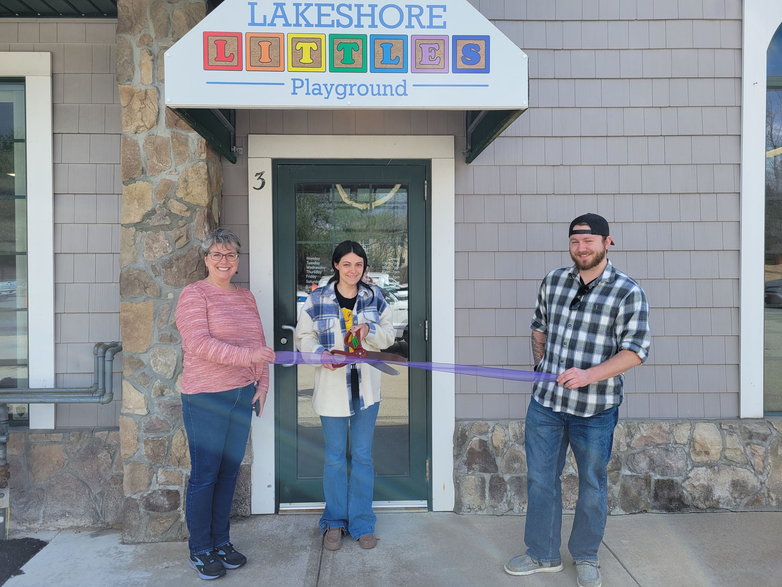 Stephanie Bruce, owner of Lakeshore Littles Playground, cuts a ribbon to officially open shop.